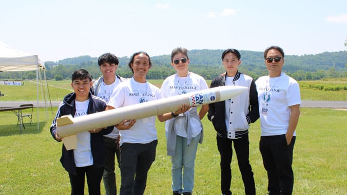 UH Maui CanSat Team holding a rocket they built