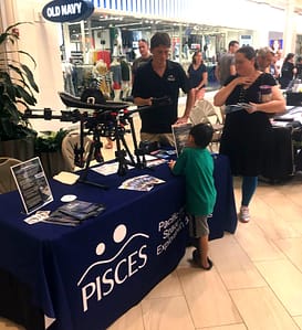 PISCES' Public Information Officer Chris Yoakum plays space trivia with a young visitor.