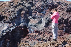 Edison photographs a lava tube burrowed into the jagged lava flows of Mauna Loa volcano near the HI-SEAS habitat.